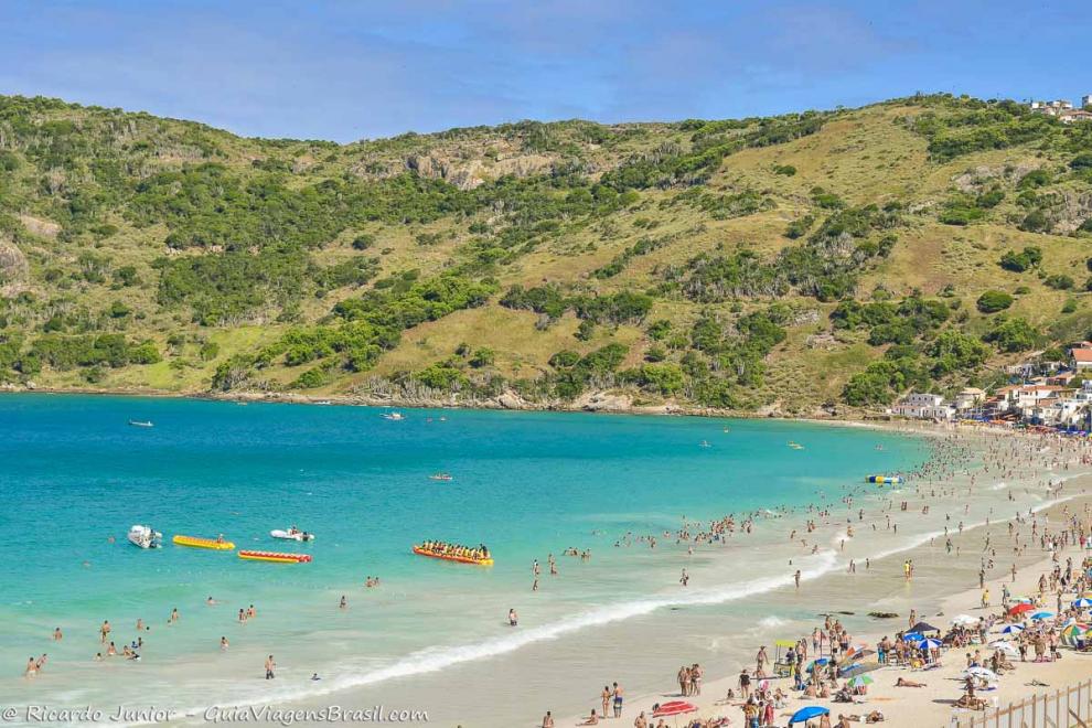 Imagem da praia repleta de turistas em Arraial do Cabo.